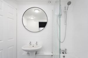 a white bathroom with a sink and a mirror at Beautiful Anfield home close to LFC stadium in Liverpool