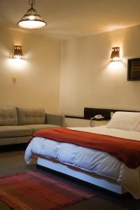 a bedroom with a bed and a couch at Hotel Pilancones in Cajamarca
