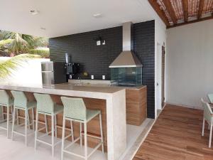 cocina con barra con taburetes y fogones en Ita Village Itacimirim - apt térreo, en Camaçari