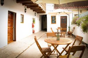 a patio with a table and chairs and an umbrella at Hotel Casa Fierro Cusco in Cusco