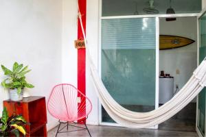 una camera con amaca, sedia e finestra di Casa Daikiri a Puerto Escondido Altre 37 foto
