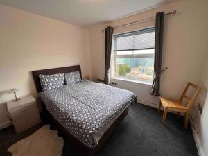 a bedroom with a bed and a window and a chair at Lincoln View. Sleeps 6. Balcony. Self check-in. in Lincolnshire