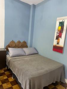 uma cama num quarto com uma parede azul em Apartamento encantador no Palácio Quitandinha em Petrópolis
