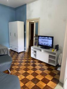 uma sala de estar com televisão e piso em xadrez em Apartamento encantador no Palácio Quitandinha em Petrópolis