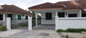 een zwart hek voor een wit huis bij Santai Homestay in Tuaran