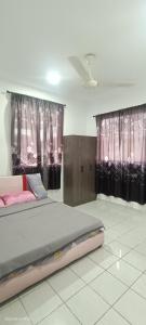 um quarto com uma cama grande e cortinas cor-de-rosa em Santai Homestay em Tuaran