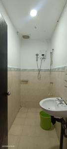 een witte badkamer met een wastafel en een douche bij Santai Homestay in Tuaran
