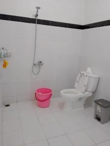 een badkamer met een toilet en een roze emmer bij Arum Bromo Villas in Ngadisari