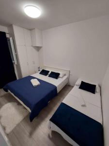 two beds in a small room with blue and white at Apartments with parking space Kraj, Pasman - 335 in Tkon