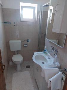 a bathroom with a white sink and a toilet at Apartments with parking space Kraj, Pasman - 335 in Tkon +15 photos