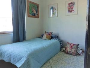 um quarto com uma cama e duas almofadas em La Casa de la Pulperia en Cerro Alegre em Valparaíso