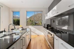 a kitchen with a sink and a stove top oven at Kinsale - Spa, Pool, Gym and Tennis! in Arrowtown