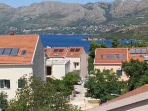 eine Gruppe von Gebäuden mit einem See im Hintergrund in der Unterkunft Apartments with a parking space Cavtat, Dubrovnik - 2132 in Cavtat