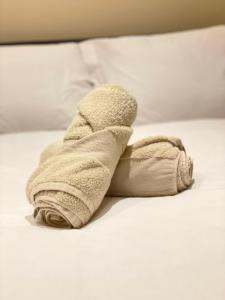 toalla enrollada encima de la cama en Green Lanes, en Londres