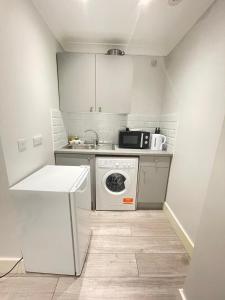 a small kitchen with a washing machine and a microwave at Green Lanes in London
