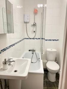 uma casa de banho com um lavatório, um WC e um chuveiro em Dalston's Rooms em Londres