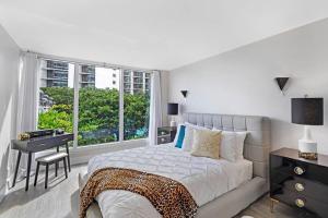 a bedroom with a bed and a desk and a window at The Palms! Direct water view corner condo in Miami +28 photos