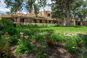 an old house with a garden in front of it at Inn on La Loma Plaza in Taos