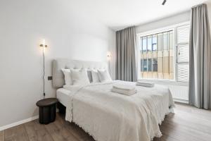 Un dormitorio blanco con una cama grande y una ventana en City View Lux in the City Center with Free Parking en Reikiavik