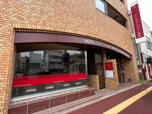 a store front of a brick building with a window at Hotel Axia Inn Kushiro in Kushiro