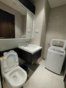 uma casa de banho com um WC, um lavatório e um espelho. em Family Room em Maribago