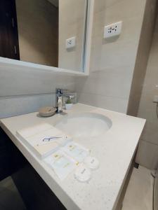Baño blanco con lavabo y espejo en Family Room en Maribago