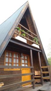 a cabin with a wooden door and a roof at CABAÑAS COPITL in Tanti