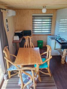 uma sala de jantar com uma mesa e cadeiras num quarto em Hostal Turismo Allipen em Melipeuco
