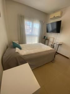 a bedroom with a large bed and a flat screen tv at Departamento TANGO - Céntrico - Balcón - Zona Cardiológico in Corrientes
