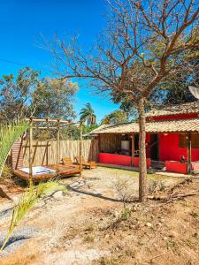 a house with a tree and a swing at Cantinhos do Cipó - Chales privativos com hidro in Serra do Cipo