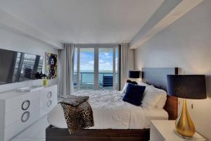 a bedroom with a bed and a large window at A Wave From It All! Direct water views! in Miami