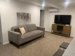 uma sala de estar com um sofá e uma televisão de ecrã plano em Entire cozy home em Madera