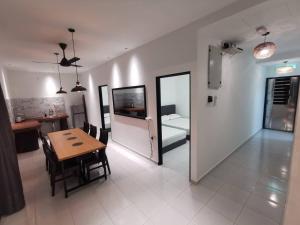 a living room with a table and a room with a kitchen at Kulim Mini HomeStay in Kulim