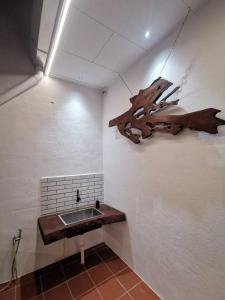 a bathroom with a sink and a wooden branch on the wall at Kulim Mini HomeStay in Kulim