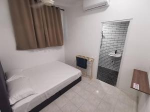 a bedroom with a bed and a bathroom with a sink at Kulim Mini HomeStay in Kulim