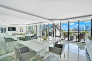 een eetkamer met een witte tafel en stoelen bij Sea Forever! Miami Skyline And Water Views in Miami