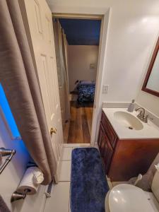 a bathroom with a sink and a toilet and a door at Chill Retreat in great location (parking onsite) in Wilmington