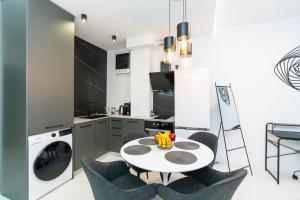 a kitchen with a table and chairs and a laundry machine at Arena MALL Galleria View and Securities Parking1 in Burgas City