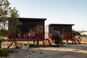 una pequeña casa con una barandilla roja al lado en Villas Quijote Valle de Guadalupe, en Bonito