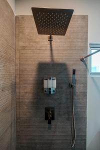 eine Dusche mit Duschkopf an der Wand in der Unterkunft Villas Quijote Valle de Guadalupe in Bonito