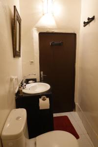 マラケシュにあるDar Suncialのバスルーム(白いトイレ、シンク付)
