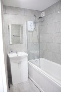 La salle de bains est pourvue d'une douche, d'un lavabo et d'une baignoire. dans l'établissement Watford Gemini - Thanet House, Nr Watford Metropolitan, M1,M25, à Watford