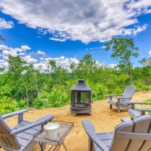 a patio with a grill and chairs and a table at WATERFRONT LUXURY GLAMPING DOME in Rogersville