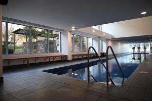 een zwembad in een gebouw met ramen en een zwembadmeester bij Accommodate Canberra - Metropolitan 70 in Canberra