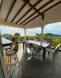 a patio with a table and chairs on a balcony at Villa NKJ'S in Deshaies