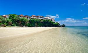 a sandy beach with condos in the background at Hyakunagaran in Nanjo