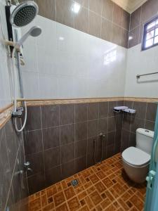 La salle de bains est pourvue d'une douche et de toilettes. dans l'établissement Homestay Nukman Bukit Besi, à Dungun