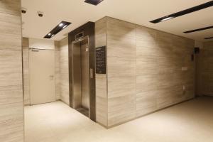 um elevador num edifício com uma placa na parede em Ramada Taebaek Hotel em Taebaek