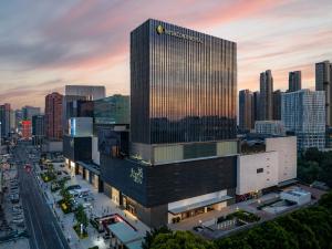 a tall building with a clock on it in a city at InterContinental Hotels Zhengzhou in Zhengzhou
