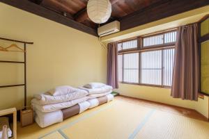 een woonkamer met een bank en een raam bij Guest House Hitsujian in Kyoto